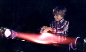 Jugando con un imán aplicado a un tubo de descarga de plasma, en un  simulador de Aurora Boreal. Cortesía de la Resonance Research Corporation